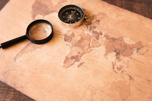 curso de geografia - um mapa e uma lupa em cima de uma mesa